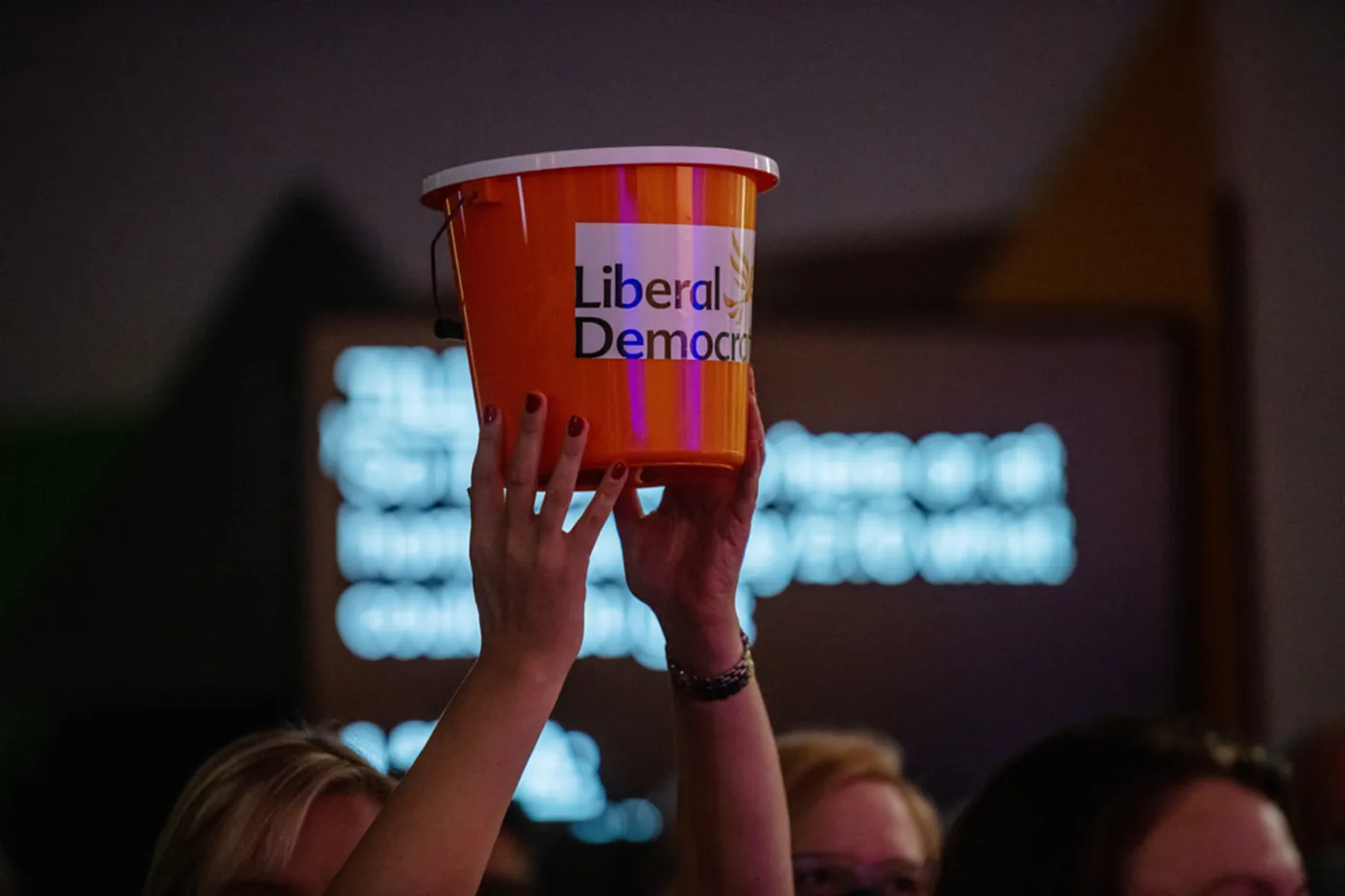 Liberal Democrat supporter with donation bucket at a party conference, 2021