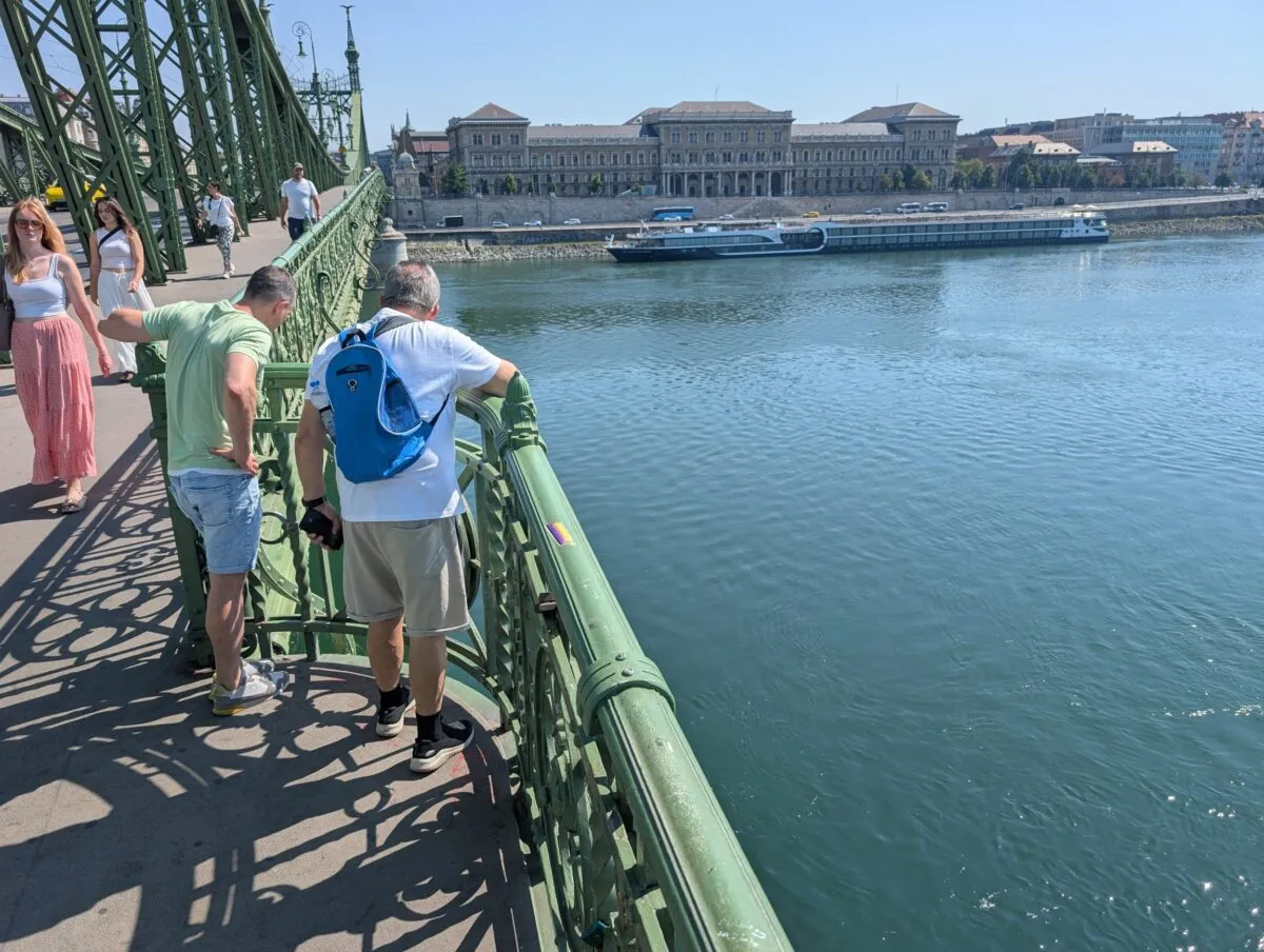 Locals inspect the old bridge remnants exposed by low water